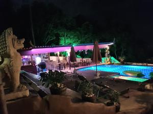 a swimming pool in front of a house at night at Moonstone Studio in Haad Rin
