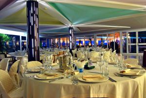 a dining room with white tables and chairs at Torre Del Sole in Terracina