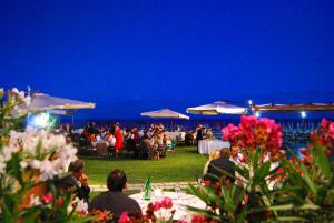 Une foule de personnes assises aux tables d'une fête la nuit dans l'établissement Torre Del Sole, à Terracine