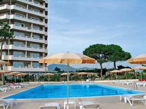 a swimming pool with chairs and umbrellas and a building at Torre Del Sole in Terracina +37 photos