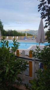a large swimming pool with umbrellas and a swimming pool at Ecochiocciola in Montese