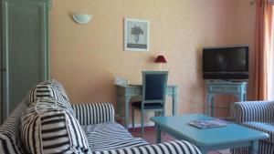 a living room with a couch and a table and a tv at Hotel Historischer Krug in Oeversee