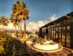 a building with palm trees in front of it at Hotel Rural Finca de La Florida in San Bartolomé