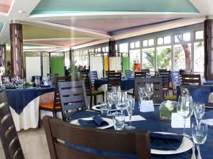 a restaurant with blue tables and chairs and windows at Torre Del Sole in Terracina