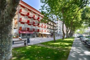 uma rua com um edifício e um parque com árvores em Micasa Inn Fátima em Fátima