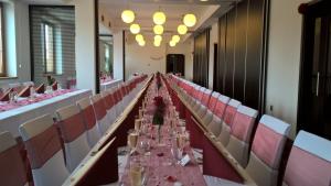 a long banquet hall with pink tables and chairs at Hotel Lužnice in Planá nad Lužnicí