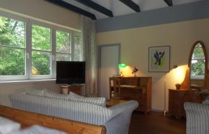 a living room with a couch and a tv at Hotel Historischer Krug in Oeversee