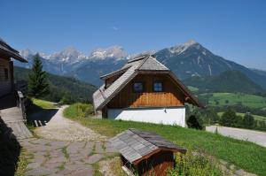 une maison sur une colline avec des montagnes en arrière-plan dans l'établissement Almresort Baumschlagerberg, à Vorderstoder