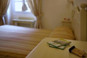 sypialnia z łóżkiem i książką na stole w obiekcie Chiaro Di Luna viale Italia w mieście Sassari
