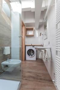 a bathroom with a washing machine and a sink at Residenza Al Cadin in Andalo