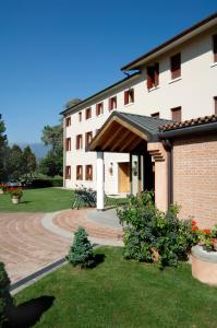 budynek z ceglanym chodnikiem przed nim w obiekcie Hotel Del Parco Ristorante Loris w mieście Pieve di Soligo