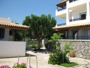 une villa avec un arbre en face d'un bâtiment dans l'établissement Maravelias House, à Archangelos