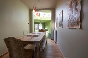 a dining room with a wooden table and chairs at Sekowa-lodge in Geraardsbergen