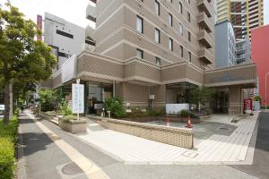 a building on a street with orange cones in front of it at Tetoranze Makuhari Inagekaigan Hotel in Chiba