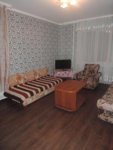 a living room with a couch and a table at Apartment in Mikrorayon 18, 11 in Zhlobin