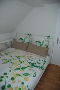 - un lit avec une couette à fleurs et 2 oreillers dans l'établissement Ferienwohnungen Lisa, à Wangen im Allgäu