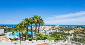 uma vista aérea de um resort com uma piscina e palmeiras em Villa Coppitella, rooms & apartments em Vieste