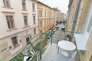 a balcony with a table and chairs looking out onto a street at Historical Centre Apartments in Lviv