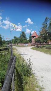 una bandera en una valla al lado de una carretera en Stadnina koni Tarka, en Zwierzyniec