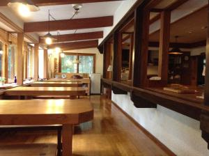 un restaurante con mesas de madera y bancos en una habitación en Inn Wataboshi en Hakuba