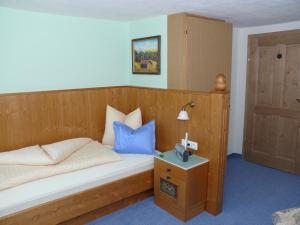 タンハイムにあるPension Obermühleのベッドルーム1室(木製ベッド1台、青い枕付)