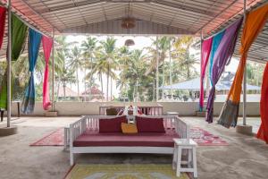 瓦尔卡拉Mad about Coco Yoga & Beach Retreat的棕榈树帐篷内的一张床位