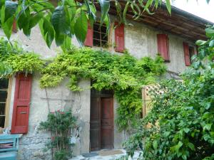 a stone house with red doors and plants at Gite de l'école in Barby