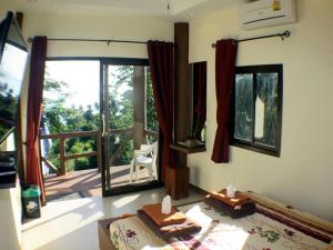 a bedroom with a large glass door with a balcony at Moonstone Studio in Haad Rin