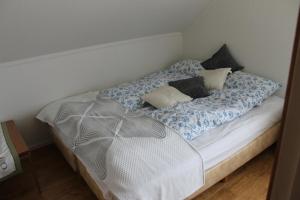 łóżko z niebiesko-białą pościelą i poduszkami w obiekcie Ferðaþjónustan Geitaskarði w mieście Geitaskard