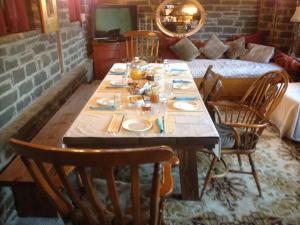 a dining room table with chairs and a couch at Traditional Rooms karaouli in Papingo