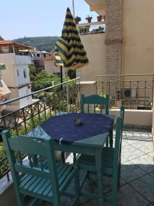 a table and chairs on a balcony with an umbrella at Dreams Studios Parga in Parga