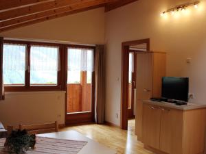 a living room with a tv and some windows at Huberhof in San Giovanni in Val Aurina