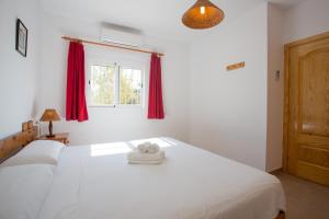 Un dormitorio con una cama blanca con una toalla. en Ca Sa Vilda, en Es Pujols