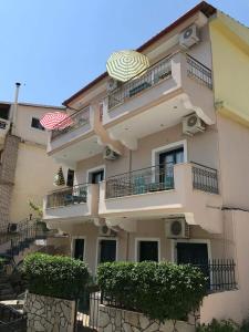 un gran edificio de apartamentos con balcones y sombrilla en Dreams Studios Parga, en Parga