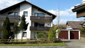 a white house with a balcony and a fence at Winterberg-Hasewinkel in Winterberg
