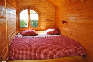 a bedroom with a bed in a wooden cabin at la Roulotte du Cos in Lamothe-Capdeville