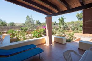 eine Terrasse mit Stühlen und Gartenblick in der Unterkunft Ca Sa Vilda in Es Pujols