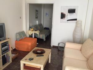 a living room with a couch and a table at Vlastos Apartment in Kalamos