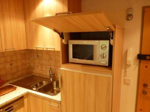 a small kitchen with a microwave and a sink at Apartment Anna in Bad Gastein