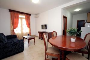 a living room with a table and a dining room at Apartmani More in Sveti Stefan