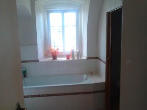 a bath tub in a bathroom with a window at Jiřetínská chaloupka in Jiřetín pod Jedlovou