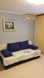 een bed met blauwe kussens in een kamer bij Apartments Danka in Pula