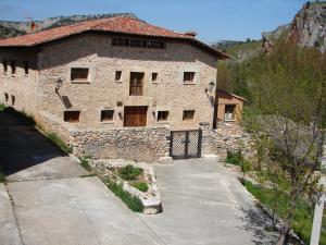 un grande edificio in pietra con un vialetto di fronte ad esso di Posada Los Templarios a Ucero