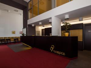 a hotel lobby with a reception desk and tables at Hotel 99 in Chomutov