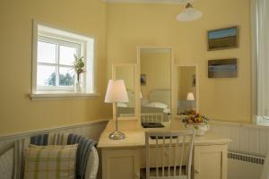 a room with a desk with a lamp and a mirror at Hjorths Badehotel in Kandestederne