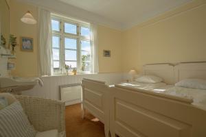 um quarto com uma cama, um lavatório e uma janela em Hjorths Badehotel em Kandestederne