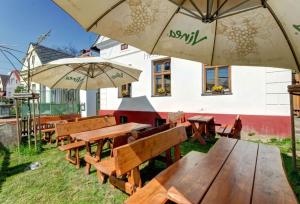 a group of wooden tables and benches with umbrellas at Slezský Grunt in Háj ve Slezsku