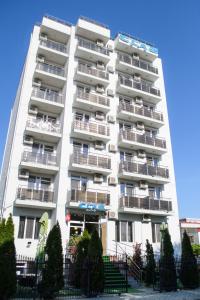 un grand immeuble d'appartements blanc avec balcon dans l'établissement Hotel Clas, à Eforie Nord