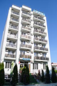 エフォリエ・ノルドにあるHotel Clasのバルコニー付きの白い高層アパートメントです。