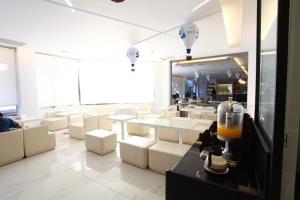 a room with white tables and white chairs and lights at Taitung Yes Hotel in Taitung City